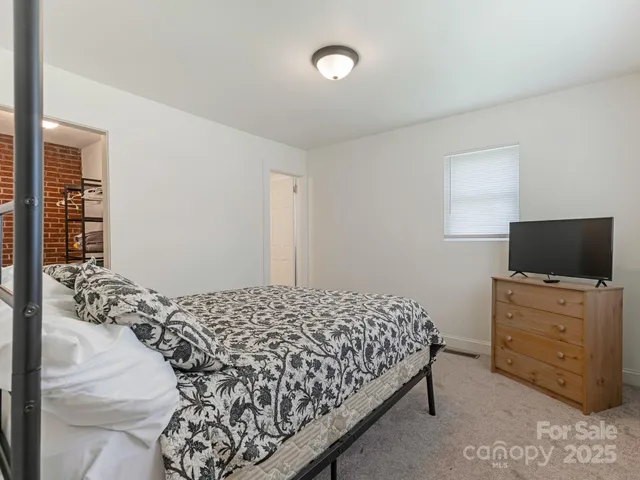a bedroom with a bed and flat screen tv
