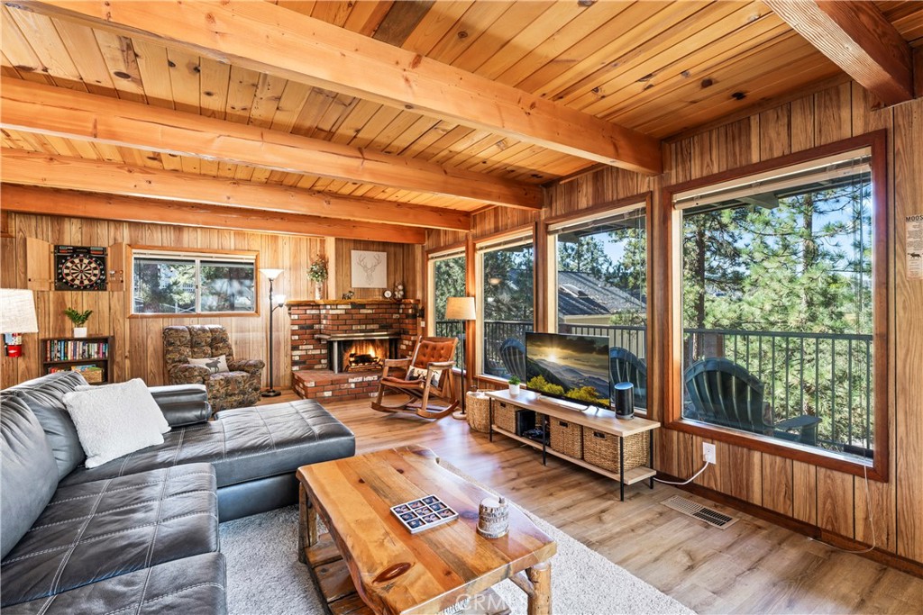 a living room with furniture a flat screen tv and floor to ceiling windows