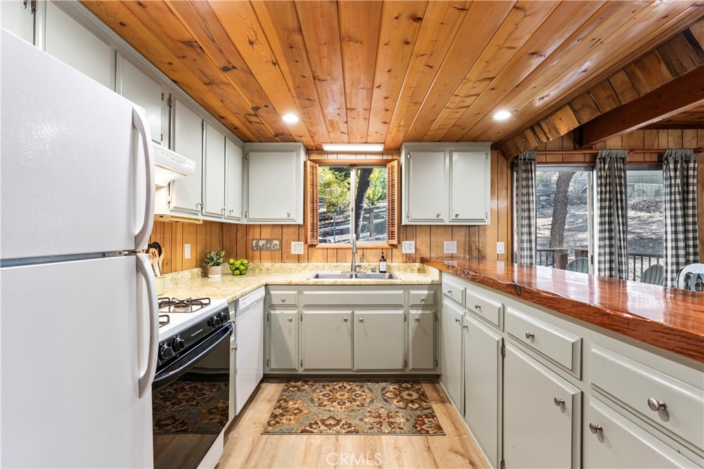 930 Bear Mountain Road Big Bear City, CA 92314 - Photo 17 of 39 a kitchen with a sink window and cabinets