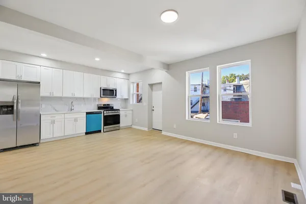 a view of kitchen with stainless steel appliances cabinets and wooden floor