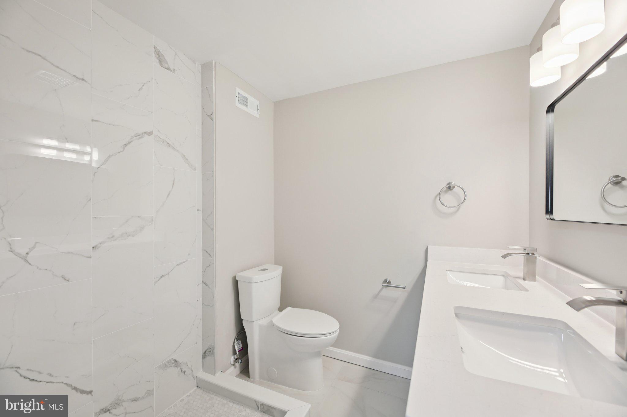 329 East University Parkway Baltimore, MD 21218 - Photo 18 of 38 a bathroom with a sink a toilet and a mirror