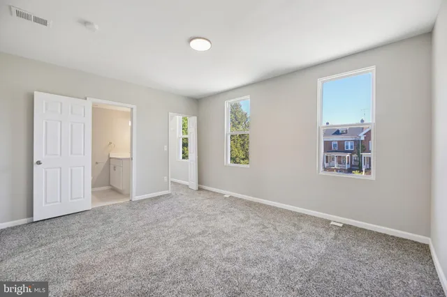 an empty room with closet and windows