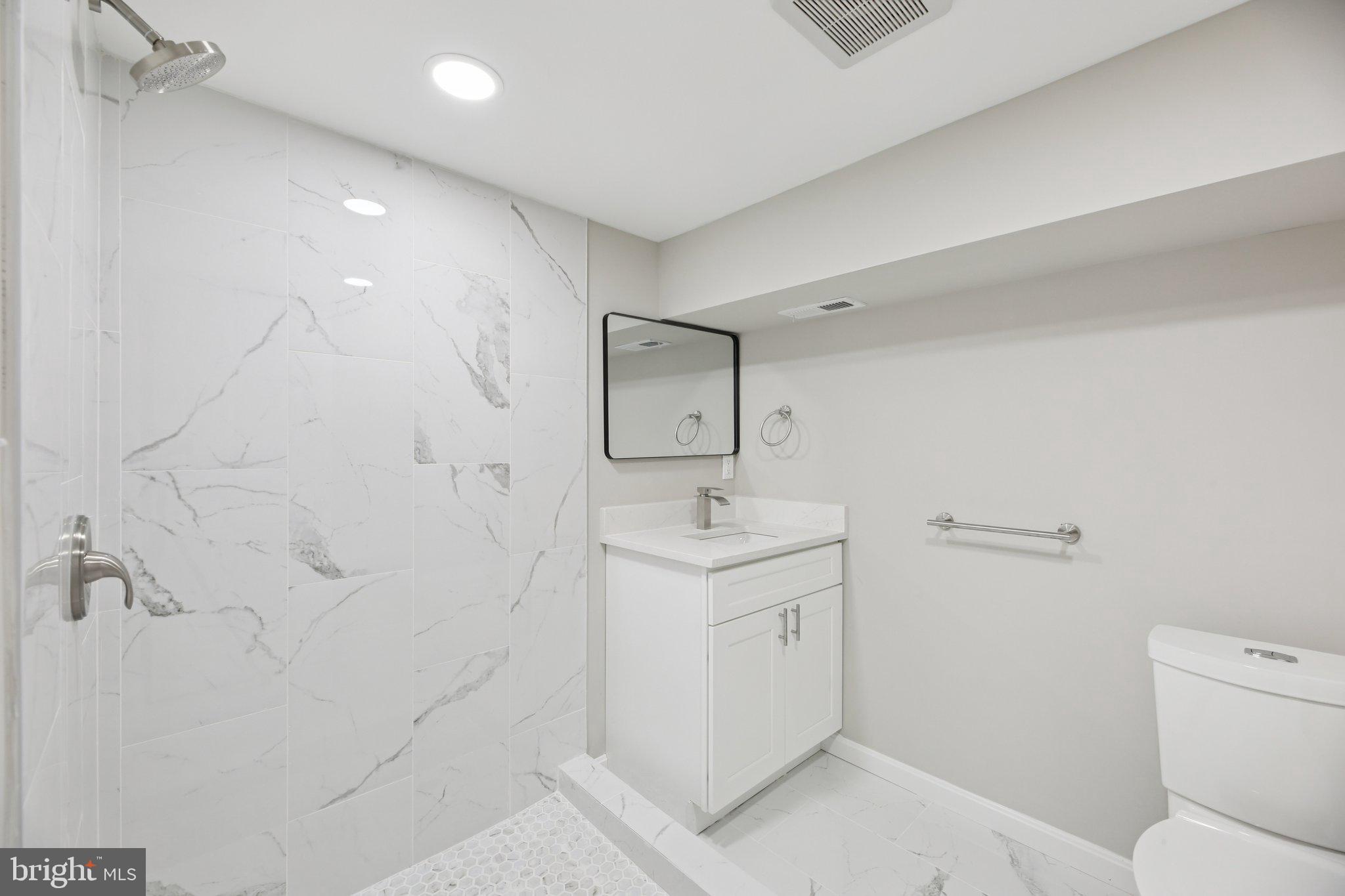 329 East University Parkway Baltimore, MD 21218 - Photo 31 of 38 a bathroom with a sink a toilet and mirror