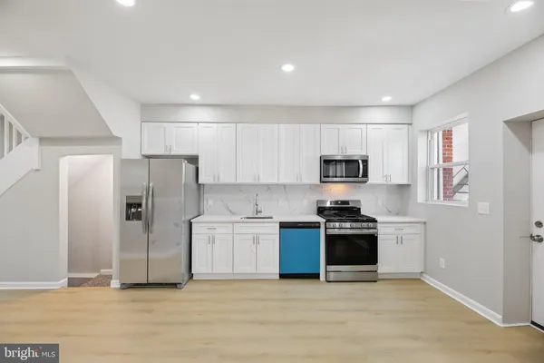 a kitchen with stainless steel appliances granite countertop a refrigerator and a sink