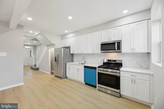 a kitchen with stainless steel appliances granite countertop a stove and a refrigerator