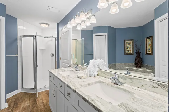 a bathroom with a granite countertop sink a large mirror and a shower