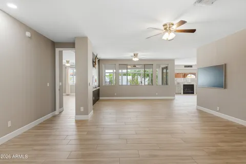 a view of an empty room with a window and wooden floor