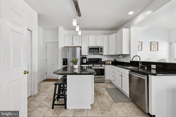 a kitchen with stainless steel appliances granite countertop a stove a refrigerator a sink dishwasher with a dining table and chairs