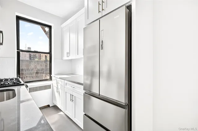 a kitchen with white cabinets and white appliances