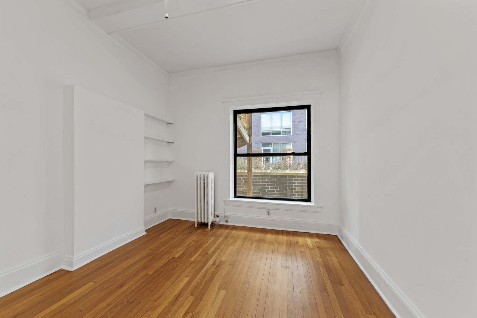 728 West Sheridan Road, Unit 2N Chicago, IL 60613 - Photo 13 of 18 an empty room with wooden floor and windows