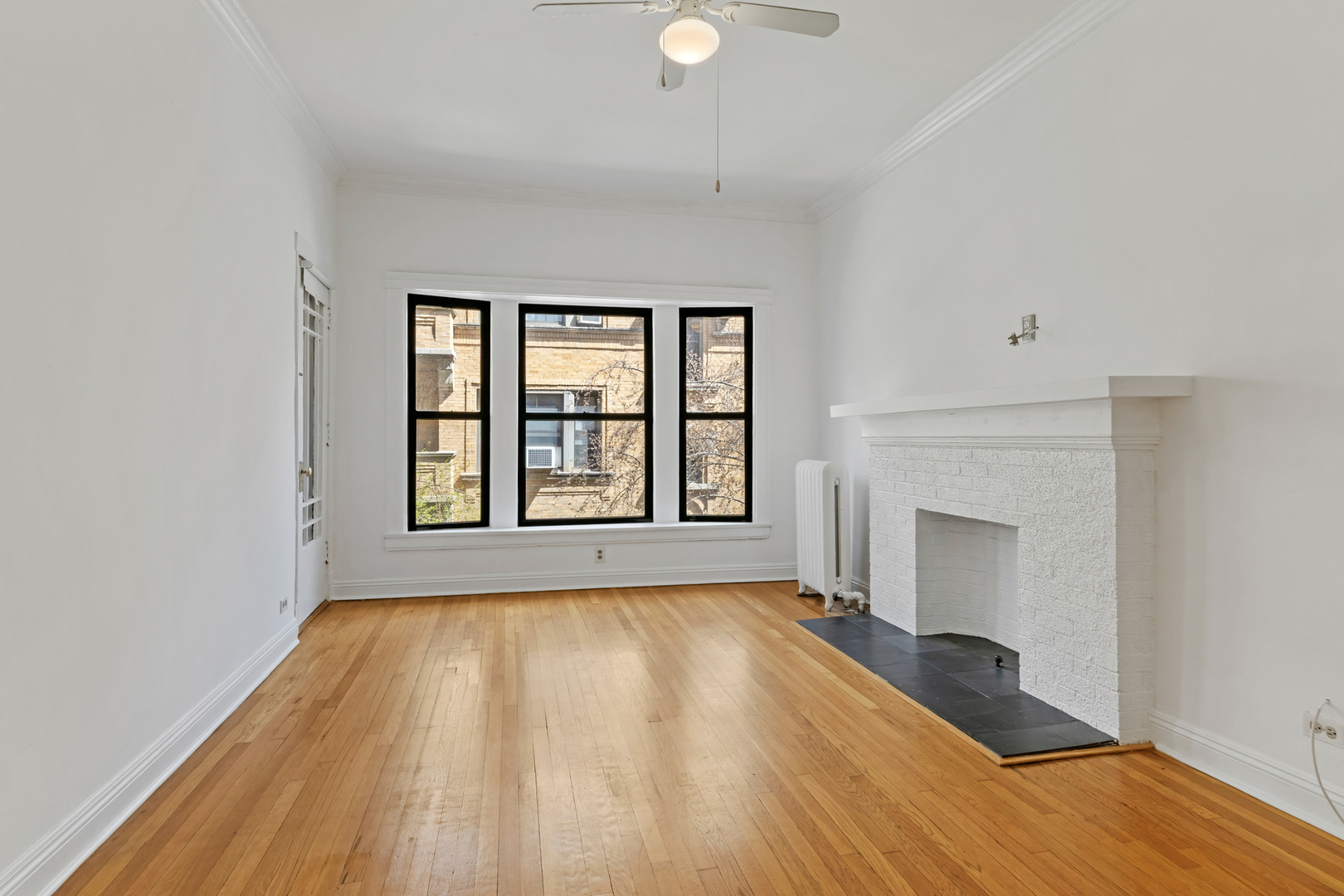 728 West Sheridan Road, Unit 2N Chicago, IL 60613 - Photo 3 of 18 wooden floor fireplace and windows in an empty room