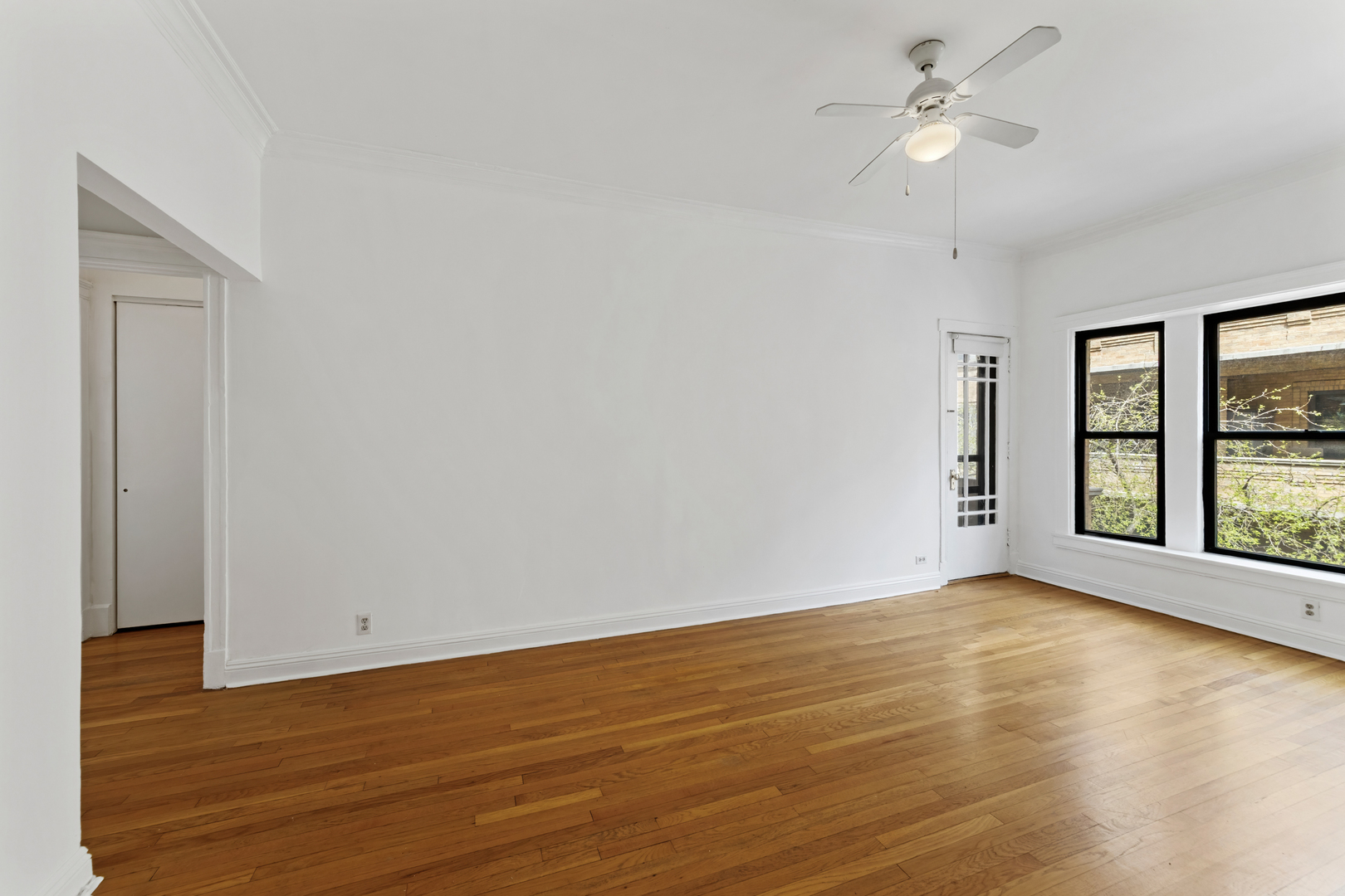 728 West Sheridan Road, Unit 2N Chicago, IL 60613 - Photo 6 of 18 an empty room with wooden floor fan and windows