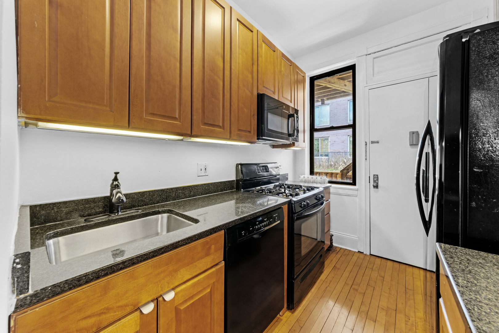 728 West Sheridan Road, Unit 2N Chicago, IL 60613 - Photo 7 of 18 a kitchen with granite countertop a sink stove and refrigerator