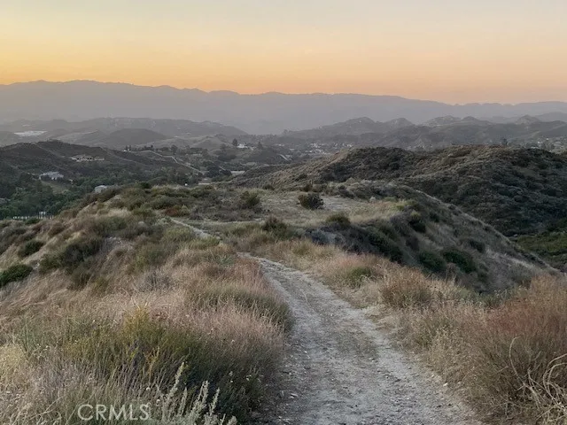 a view of a dry yard with mountains in the background