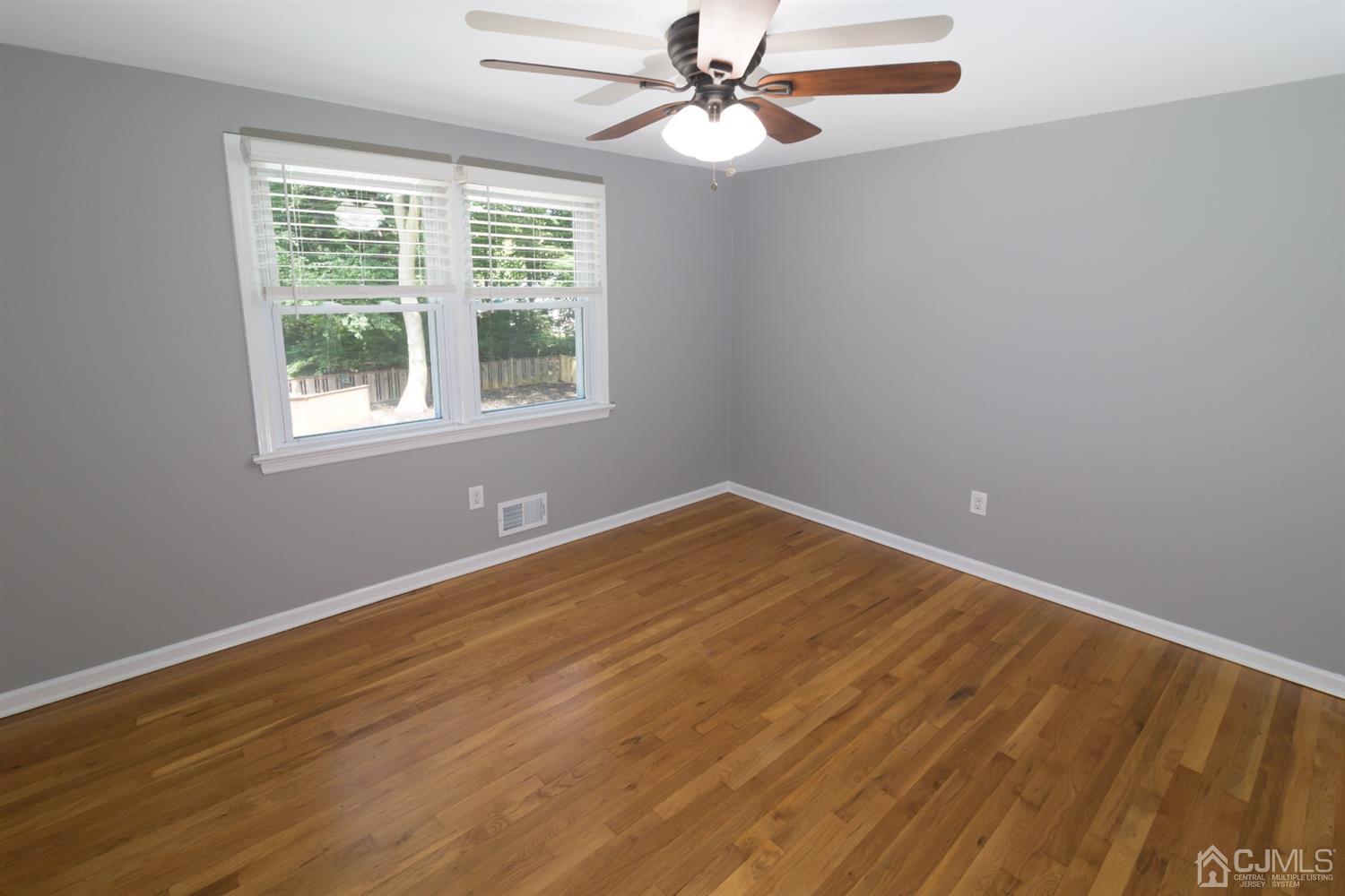 6 Coventry Square Holmdel, NJ 07733 - Photo 28 of 36 a view of an empty room with wooden floor and a window