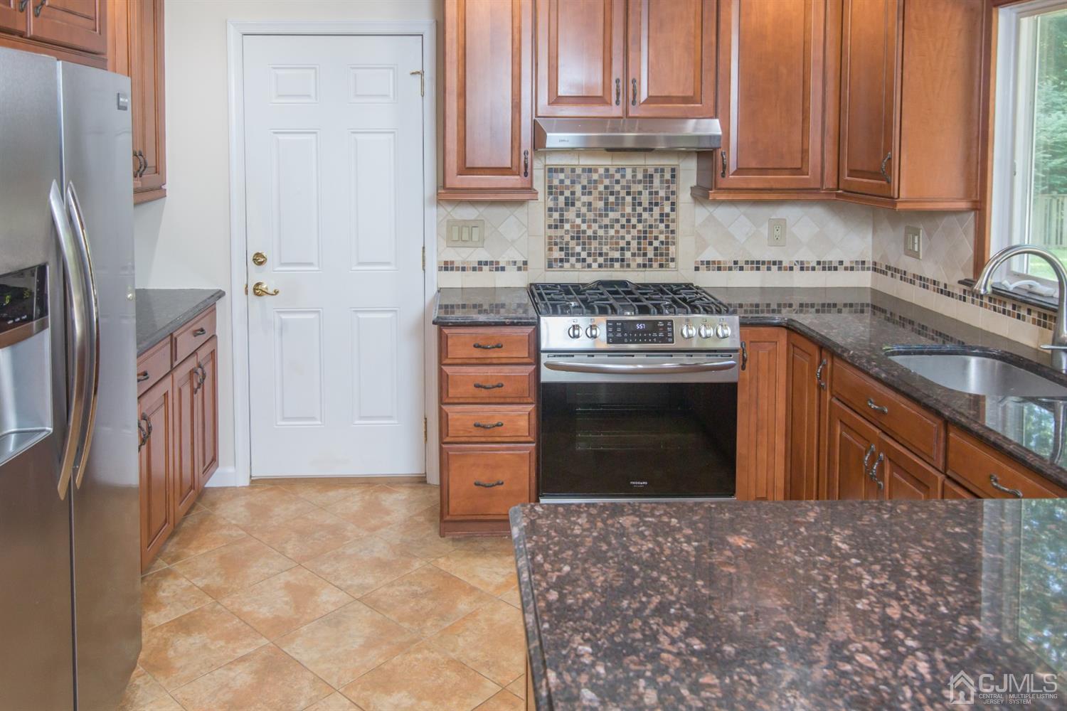 6 Coventry Square Holmdel, NJ 07733 - Photo 4 of 36 a kitchen with stainless steel appliances granite countertop a refrigerator stove and sink