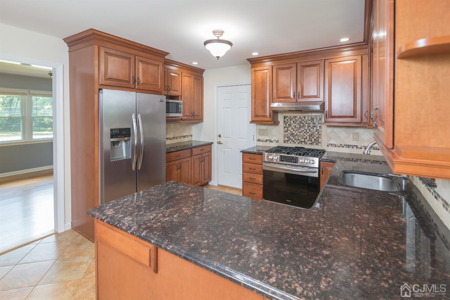 6 Coventry Square Holmdel, NJ 07733 - Photo 5 of 36 a kitchen with stainless steel appliances granite countertop a stove a sink and a refrigerator