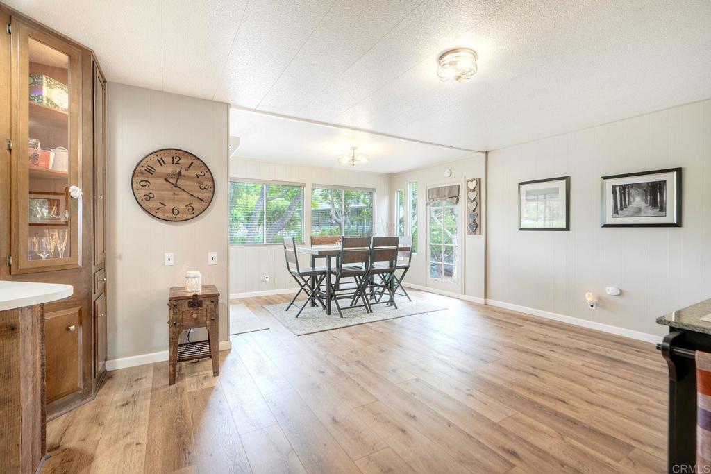 18218 Paradise Mountain Road Valley Center, CA 92082 - Photo 12 of 42 a dining room with wooden floor a chandelier a wooden table and chairs