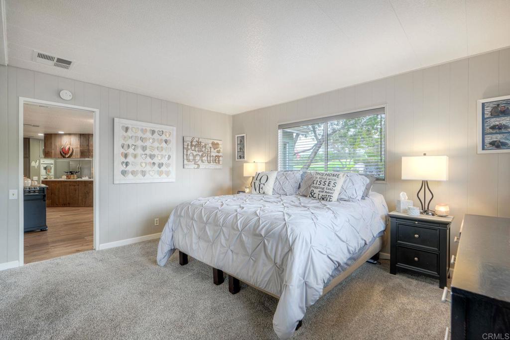 18218 Paradise Mountain Road Valley Center, CA 92082 - Photo 28 of 42 a spacious bedroom with a bed and a lamp on a dresser