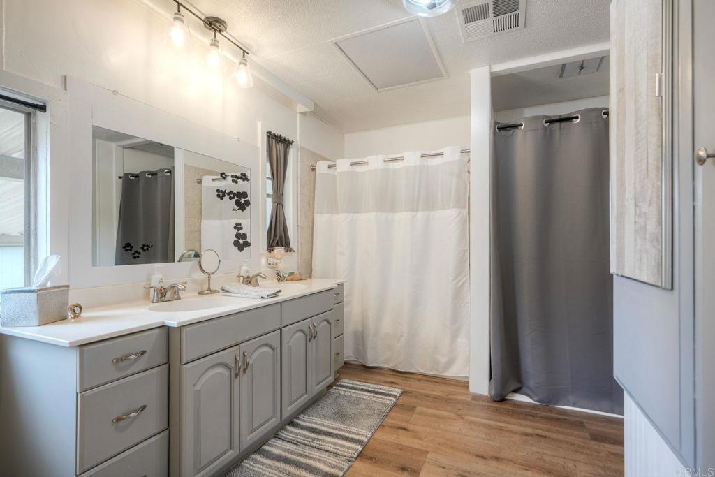 18218 Paradise Mountain Road Valley Center, CA 92082 - Photo 30 of 42 a spacious bathroom with a double vanity sink a mirror and a shower