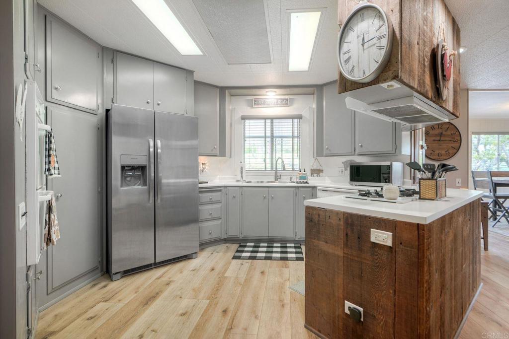 18218 Paradise Mountain Road Valley Center, CA 92082 - Photo 8 of 42 a kitchen with a stove a refrigerator and a clock on the wall