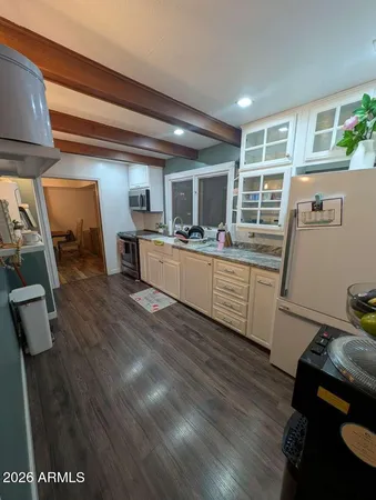 a kitchen with wooden floors and appliances