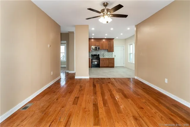 a view of a kitchen with wooden floor and a ceiling fan