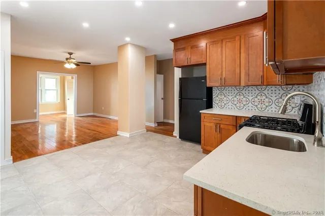 a kitchen with granite countertop a sink a stove and a refrigerator