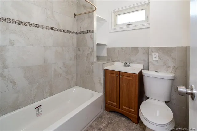 a white toilet sitting next to a bath tub