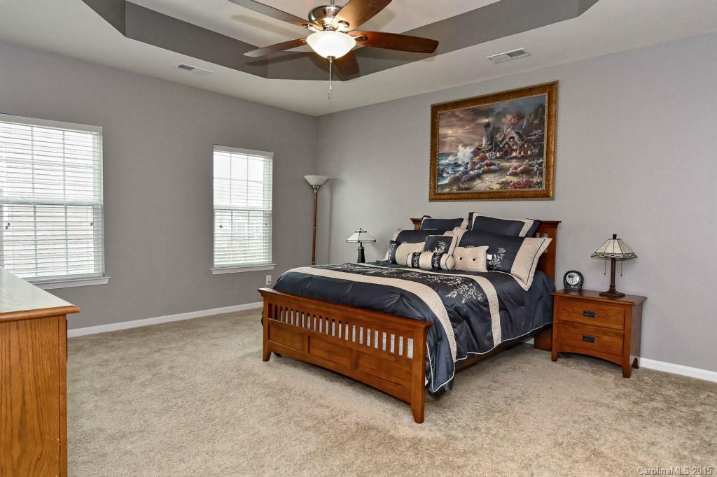 1621 Ridgehaven Road, Unit 240 Waxhaw, NC 28173 - Photo 12 of 24 a spacious bedroom with a bed and a chandelier
