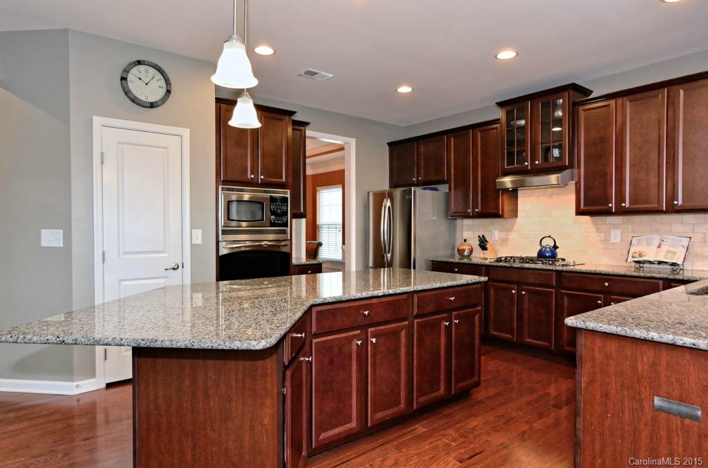 1621 Ridgehaven Road, Unit 240 Waxhaw, NC 28173 - Photo 10 of 24 a kitchen with stainless steel appliances granite countertop wooden cabinets a refrigerator a sink and wooden floors