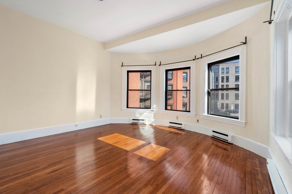857 Beacon Street, Unit 23 Boston, MA 02215 - Photo 5 of 15 a view of an empty room with wooden floor and a window
