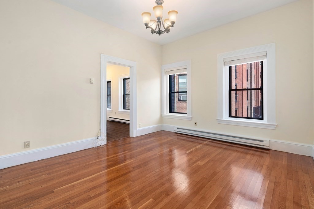 857 Beacon Street, Unit 23 Boston, MA 02215 - Photo 6 of 15 a view of an empty room with wooden floor and a window