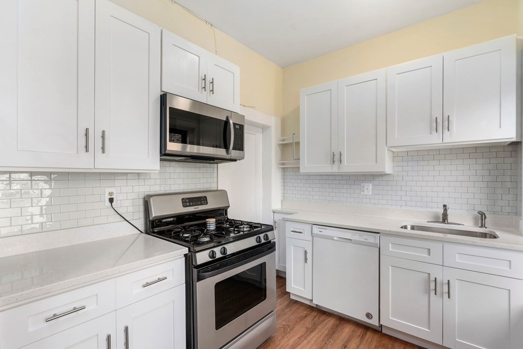 857 Beacon Street, Unit 23 Boston, MA 02215 - Photo 9 of 15 a kitchen with stainless steel appliances granite countertop white cabinets a sink a stove and dishwasher