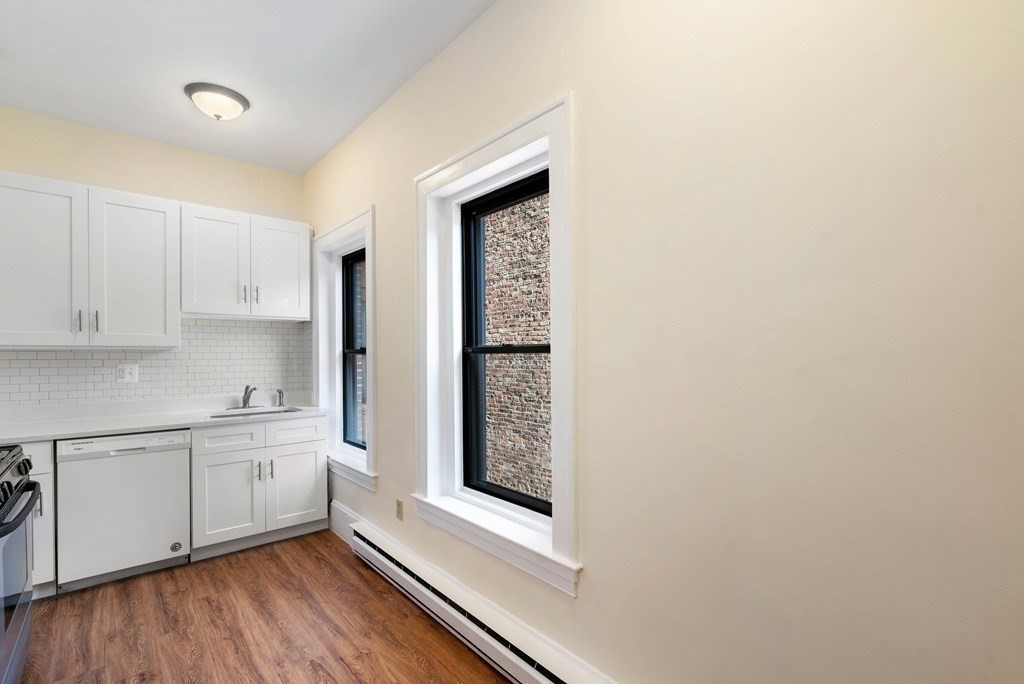 857 Beacon Street, Unit 23 Boston, MA 02215 - Photo 10 of 15 a kitchen with stainless steel appliances granite countertop a sink and wooden floor