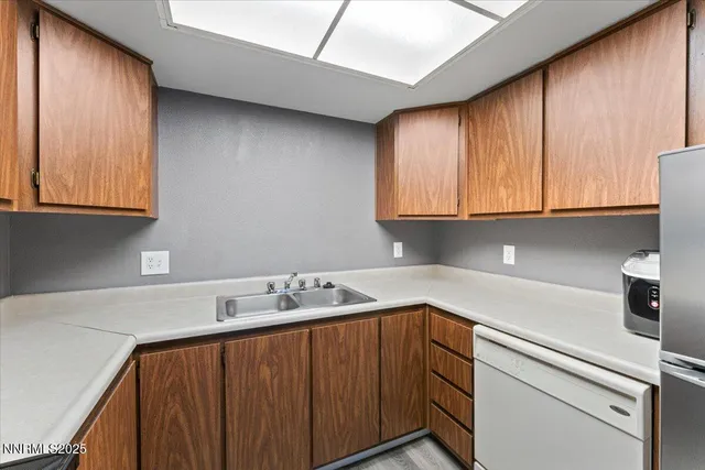 a utility room with sink dryer and cabinets