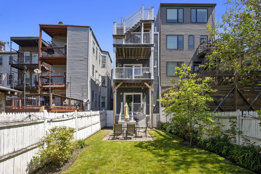 299 Sumner Street, Unit 1 Boston, MA 02128 - Photo 9 of 23 a front view of a house with a yard