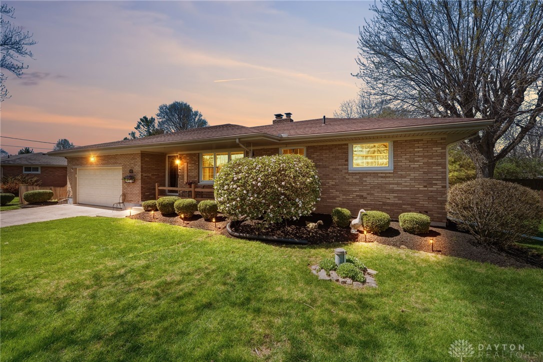 This charming residence offers a warm welcome with its brick facade and meticulously landscaped yard.