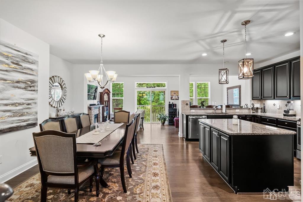 55 Isabelle Court Evesham, NJ 08053 - Photo 10 of 37 a kitchen with stainless steel appliances granite countertop a stove a refrigerator a kitchen island a dining table and chairs with wooden floor