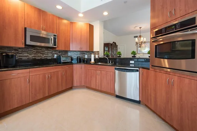 a kitchen with stainless steel appliances a sink a stove top oven a counter space and cabinets