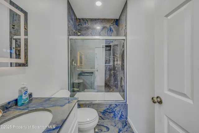 a bathroom with a granite countertop toilet sink and shower