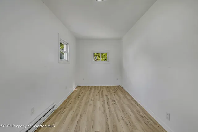 a view of empty room with wooden floor