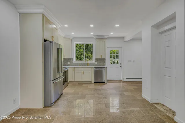 a kitchen with stainless steel appliances a refrigerator sink and cabinets