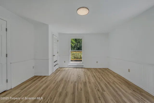 a view of a room with wooden floor and window