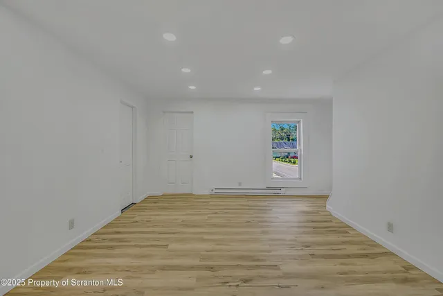 a view of room with window and wooden floor