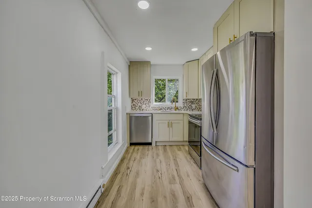 a kitchen with white cabinets and stainless steel appliances