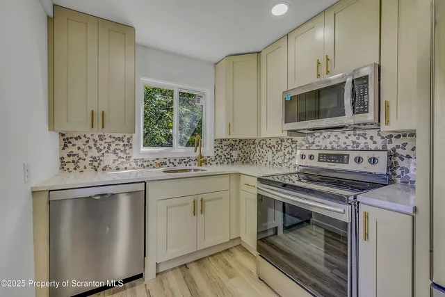 a kitchen with stainless steel appliances a sink stove and cabinets