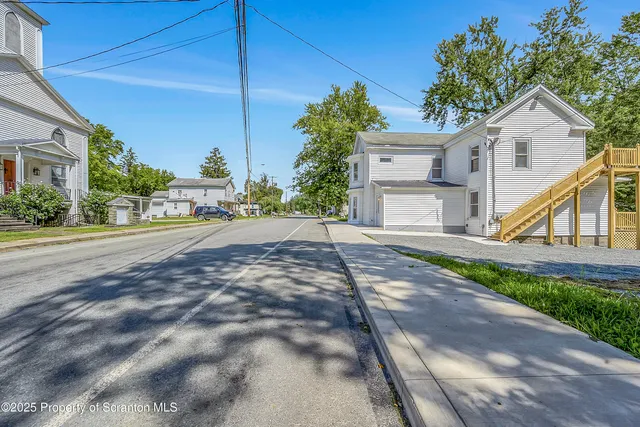 a view of a house with a yard and potted plants