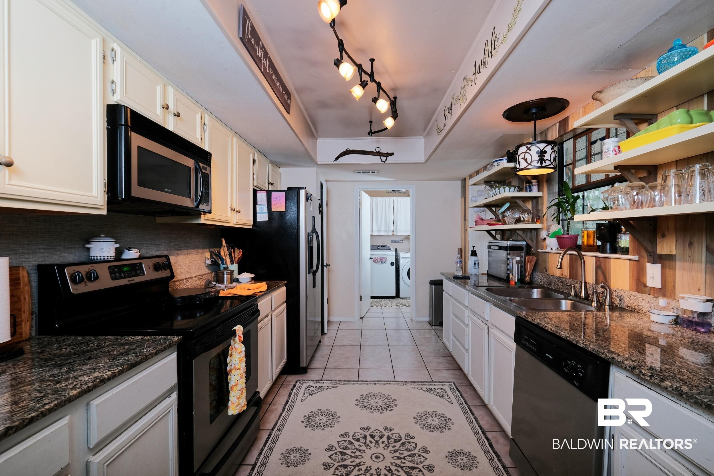 504 Ariel Avenue Foley, AL 36535 - Photo 17 of 33 Kitchen featuring white cabinets, sink, appliances with stainless steel finishes, light tile patterned floors, and track lighting