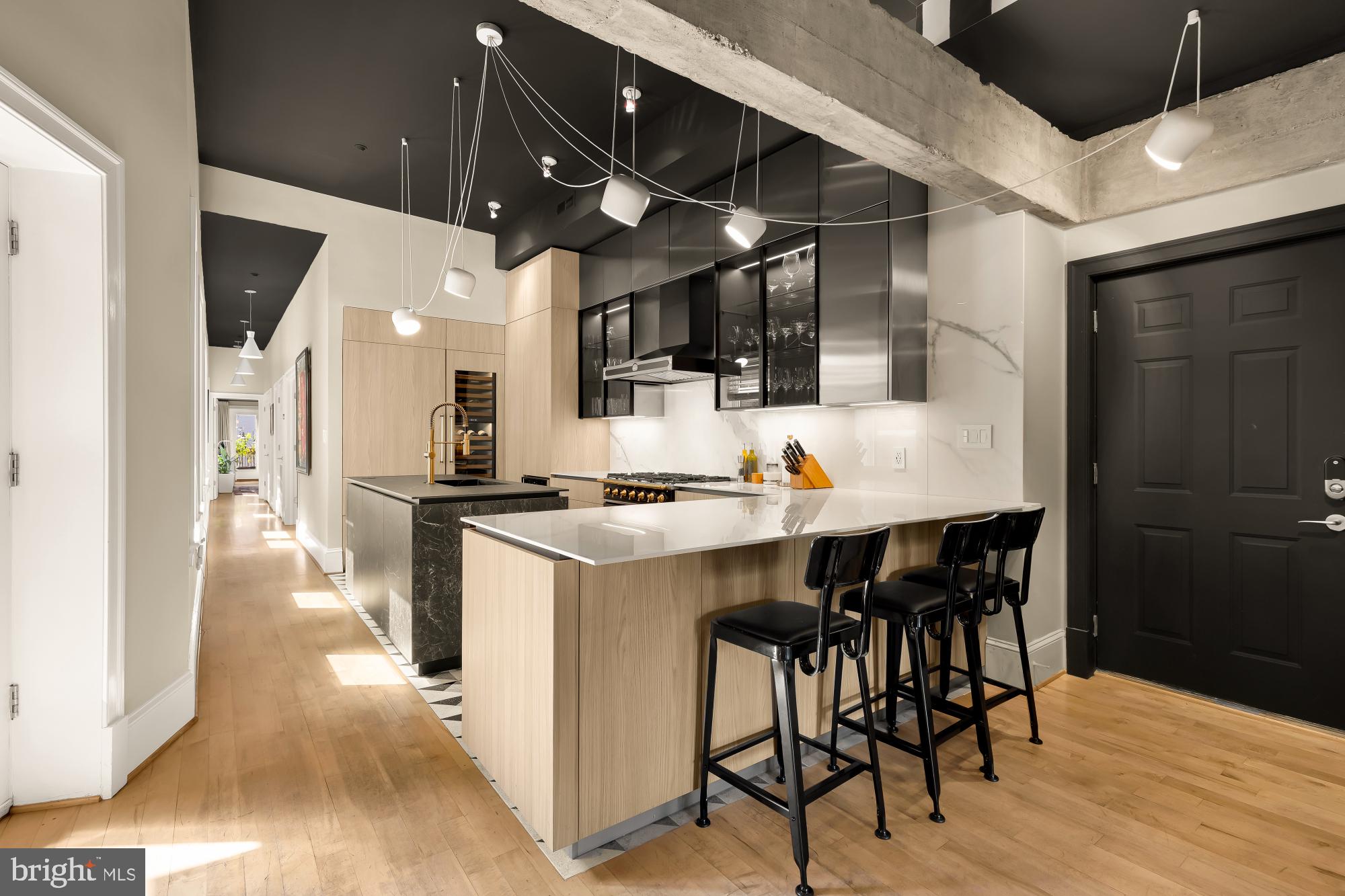 1220 N Street Northwest, Unit 4B Washington, DC 20005 - Photo 10 of 25 a kitchen with stainless steel appliances kitchen island granite countertop a table chairs sink and cabinets